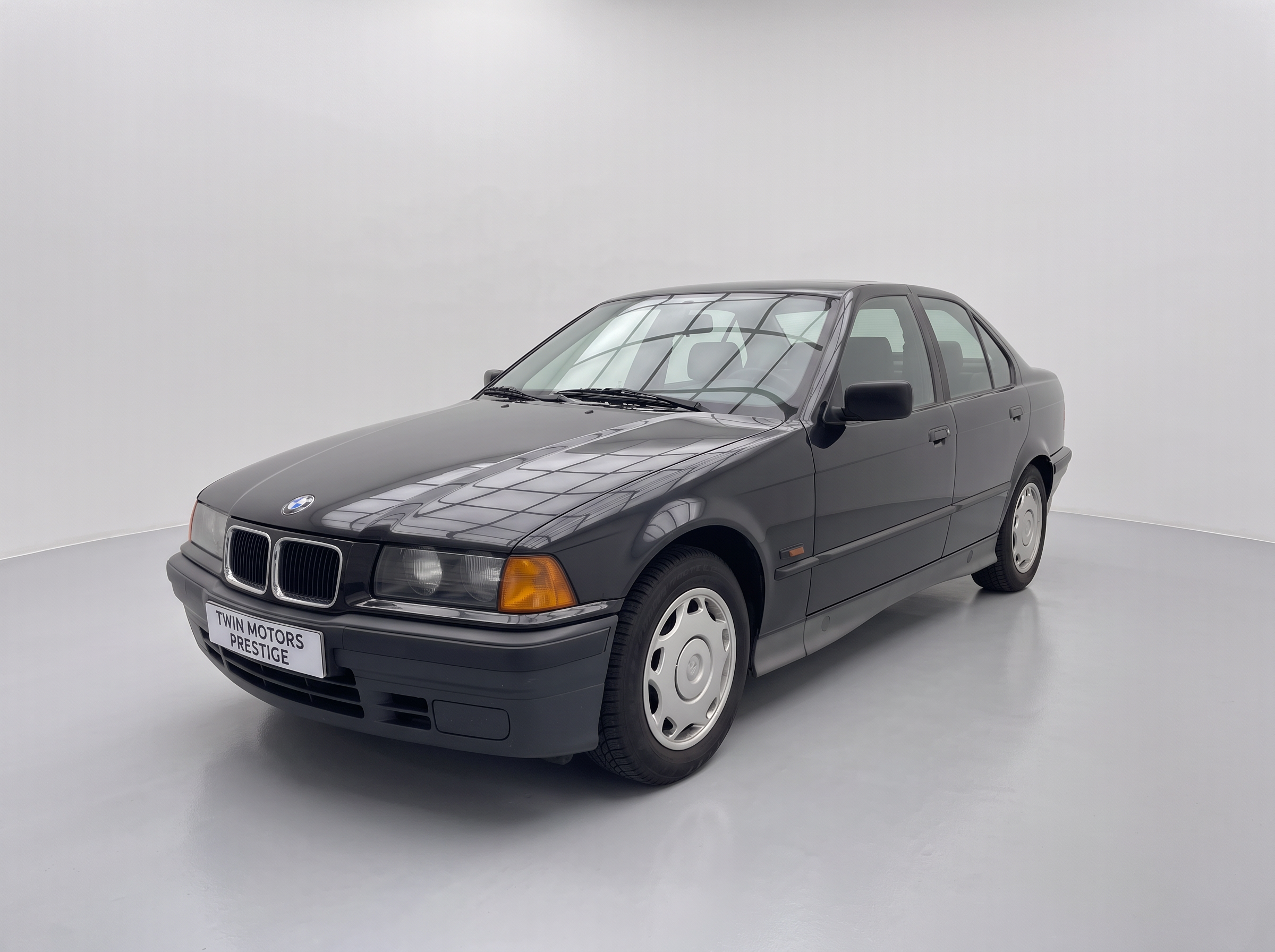 BMW Série 3 E36 316i noire vue de trois-quarts avant dans le garage