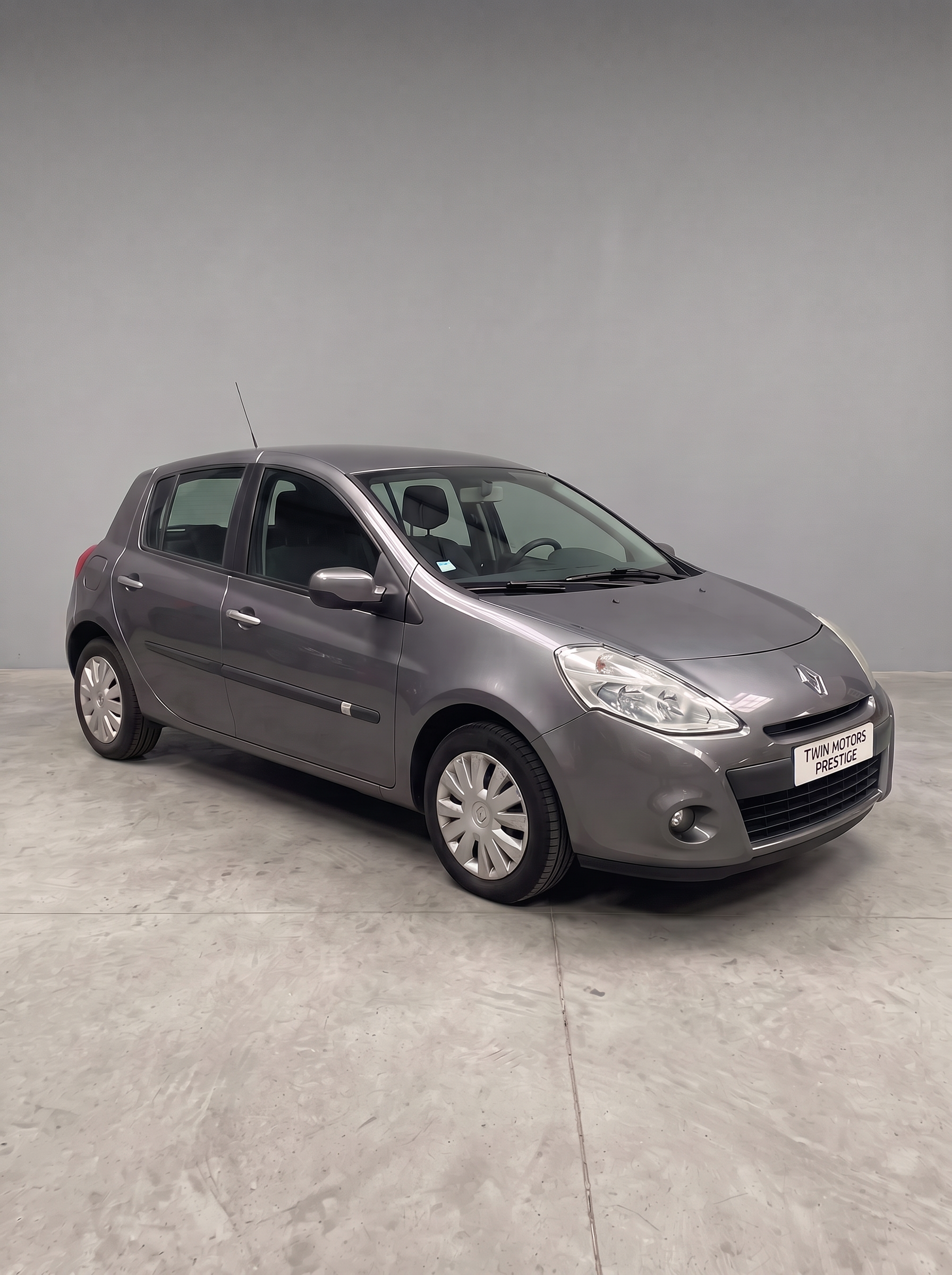 Renault Clio 3 grise vue de trois-quarts avant dans le garage