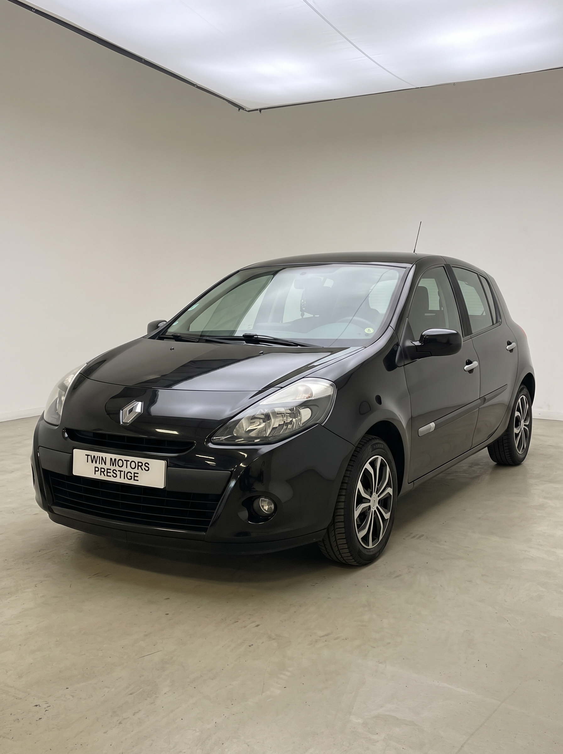 Renault Clio 3 noire vue de trois-quarts avant dans le garage