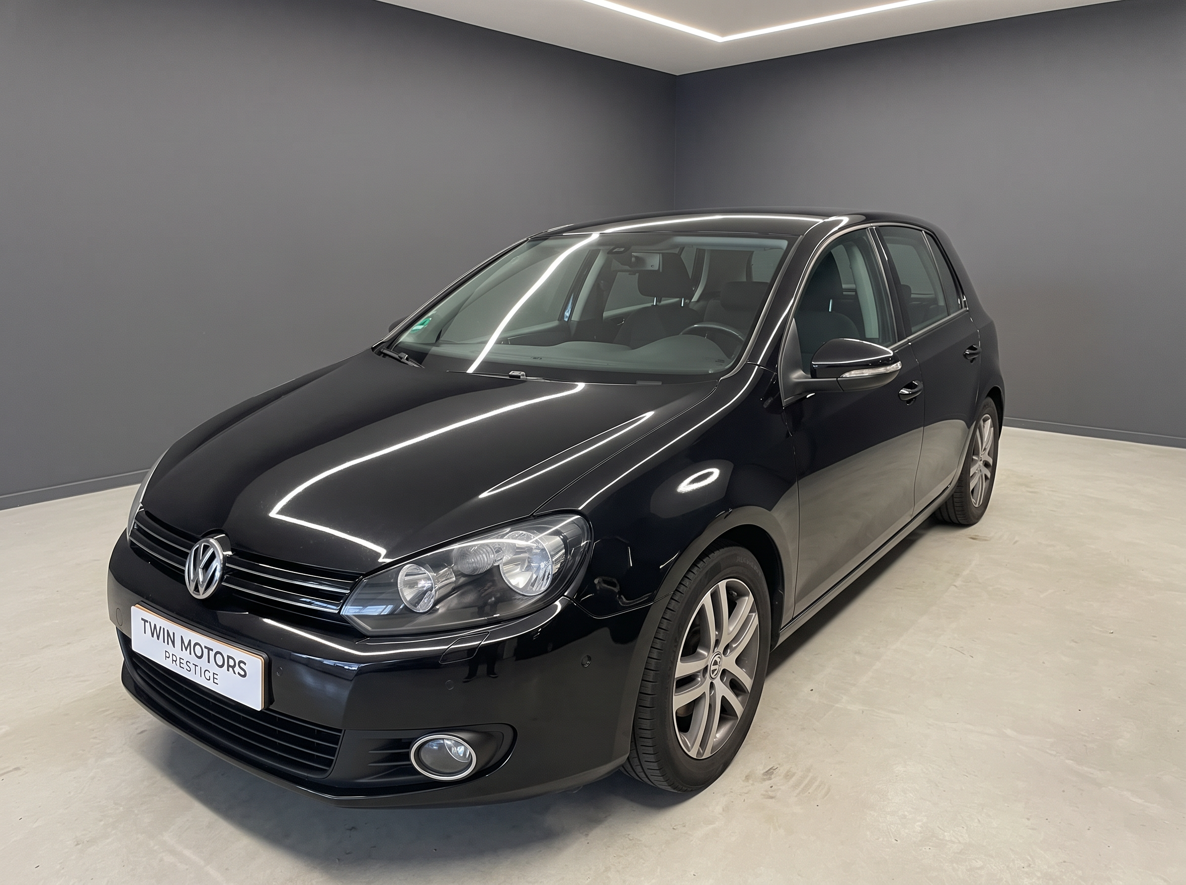 Volkswagen Golf 6 noire vue de trois-quarts avant dans le garage
